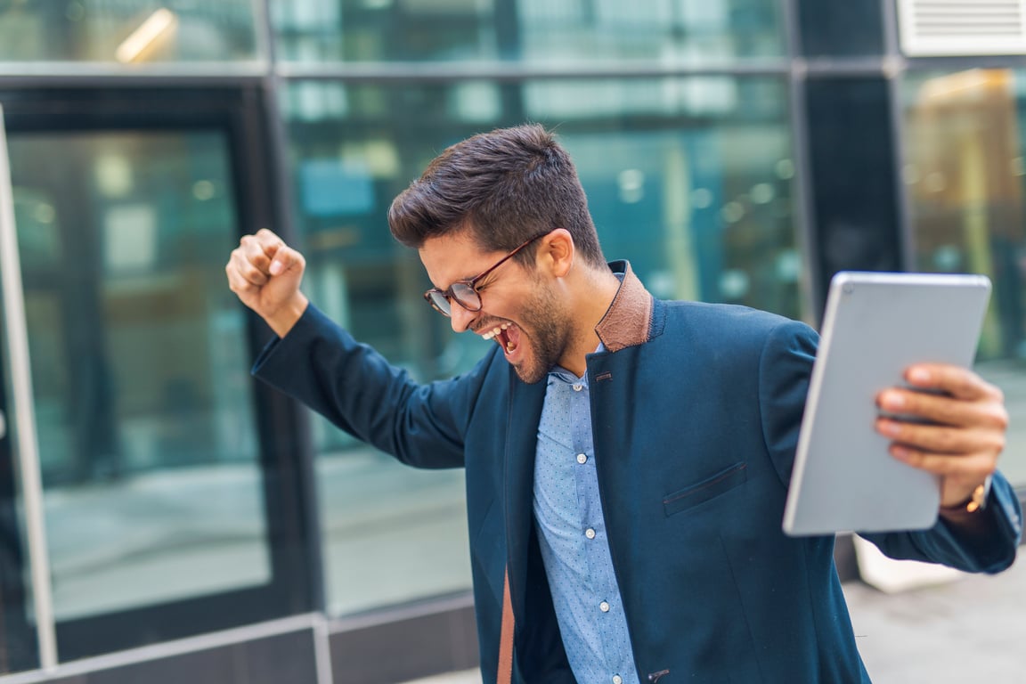 Happy Businessman Holding a Tablet Outdoors